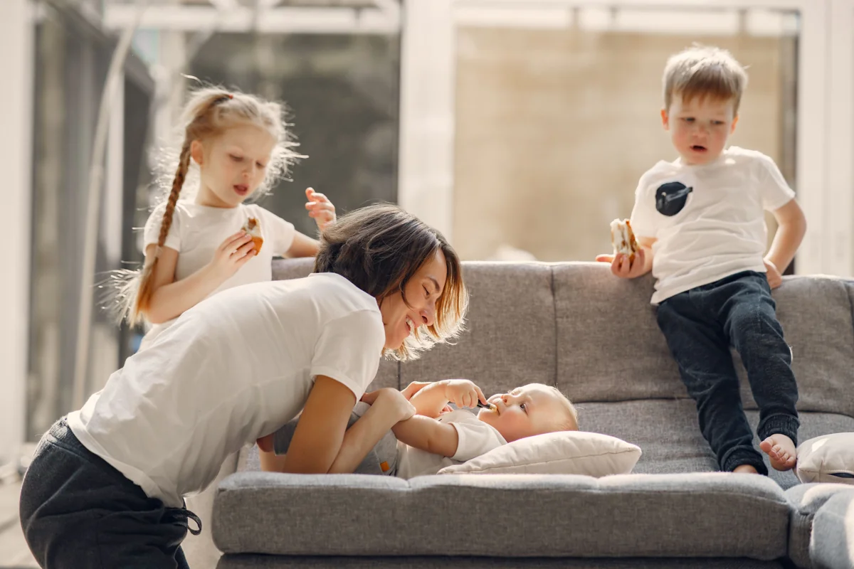 Illustrative stock photograph of an adult spending time with three children at home